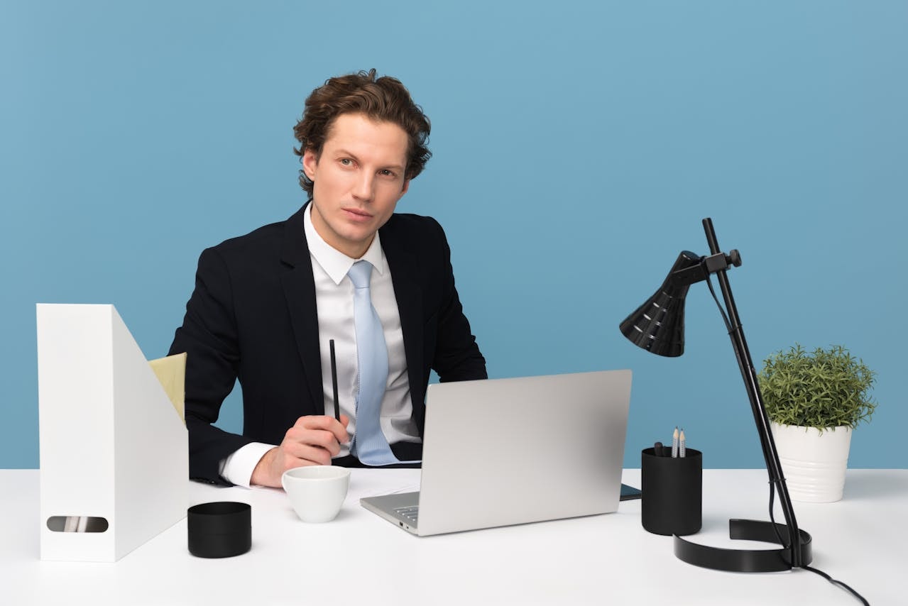 man-sitting-with-laptop-computer-on-desk-and-lamp